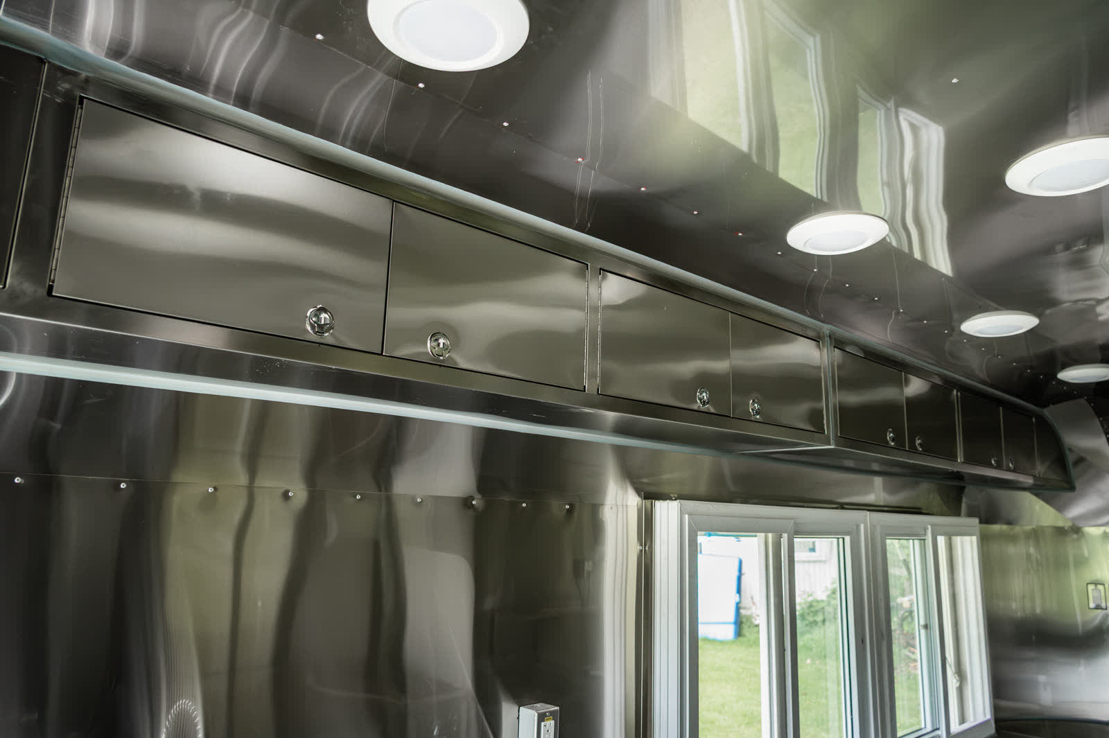 Overhead stainless storage cabinets and recessed LED lighting