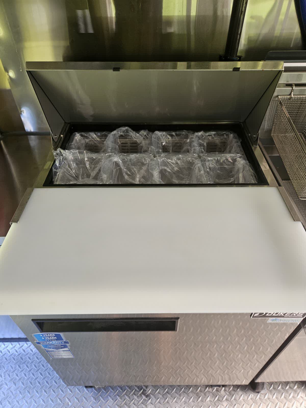 Refrigerated prep station with pan wells and cutting board